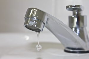 Modern faucet closeup with cute water drop